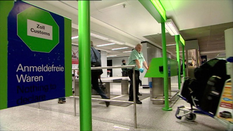 Bildunterschrift: Wer durch das grüne Portal schreitet, sollte eigentlich keine zollpflichtige Ware mit sich führen. Doch die Beamten wissen, dass es unter den Passagieren auch „schwarze Schafe“ gibt. – Bild: N24 Doku