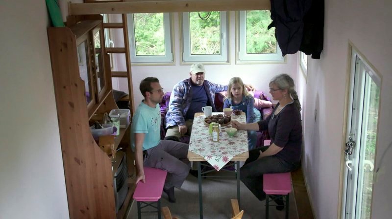 Kaffeetrinken im Minihaus: Sabine Müller (r) hat ihre neuen Nachbarn in ihr 18 Quadratmeter kleines Haus eingeladen. – Bild: WDR