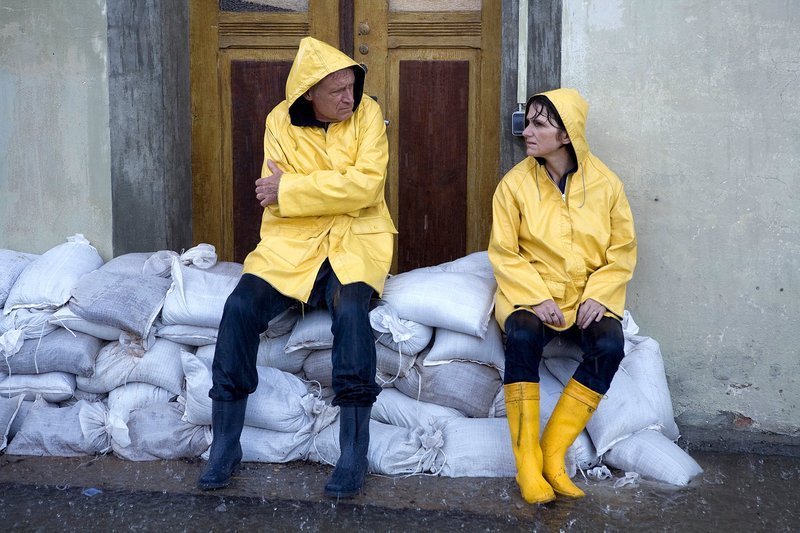Hubertys (Robert Atzorn und Victoria Trauttmansdorff) sitzen vollkommen fertig auf den Sandsäcken. Das Wasser steigt. – Bild: MDR/​Conny Klein