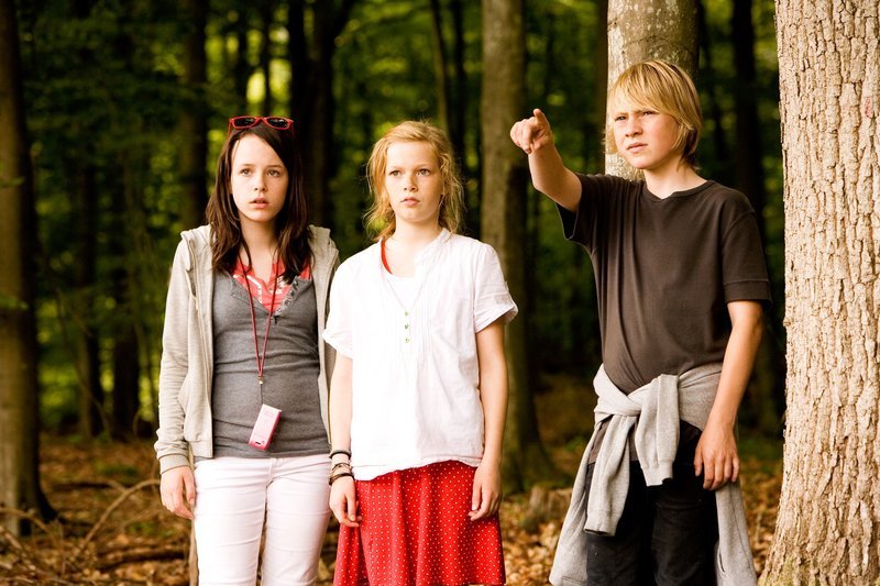 Jonas (Joshua Berman) zeigt Karla (Elena Arndt-Jensen) und Katrine (Nanna Finding) das verlassene Haus. – Bild: KI.KA/​Jens Juncker-Jensen