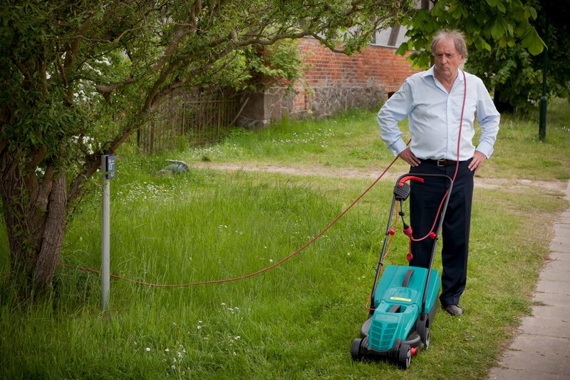 Leo (Günther Maria Halmer) will den Rasen mähen und dabei eine gute Figur dem Nachbarn gegenüber machen. – Bild: ZDF und Conny Klein