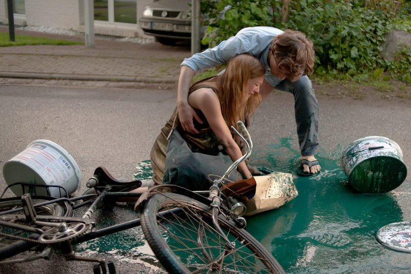 Max (Florian Stetter) hilft Iris (Hannah Herzsprung) auf die Beine, als sie mitsamt ihrer Ladung aus dem Baumarkt vom Fahrrad gefallen ist. – Bild: ZDF und Gordon A. Timpen