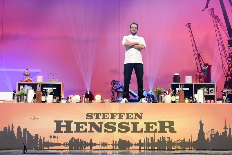 In ‚Steffen Henssler live! Hamburg, New York, Tokio – Meine kulinarische Weltreise‘ kocht sich Steffen Henssler rund um den Globus, und das Publikum erfährt dabei viel Wissenswertes. Henssler schildert auf der Bühne seine Eindrücke von Reisen in Länder wie USA, China und Japan. – Bild: RTL /​ Christoph Assmann