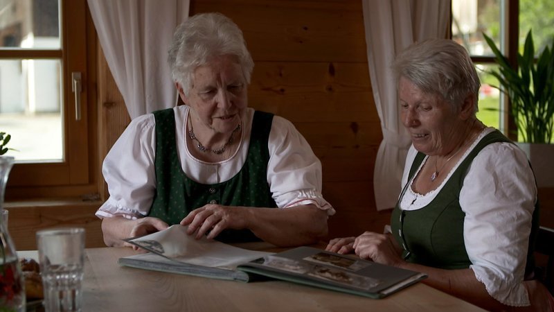 Frau Leskova und Frau Tösch mit einem Fotoalbum. – Bild: ORF