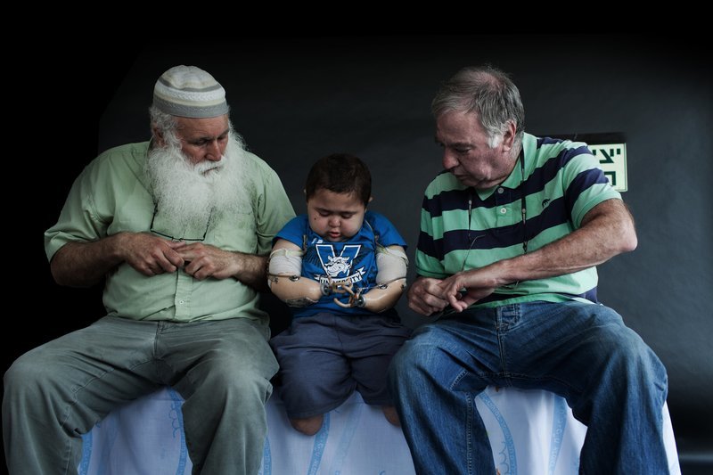 Starker Zusammenhalt: Muhi (Mitte) übt zusammen mit seinem Großvater Abu Naim (links) und seinem israelischen Betreuuer Buma Inbar (rechts) den Umgang mit seinen Prothesen. – Bild: ZDF und Rina Castelnuovo-Hollander.