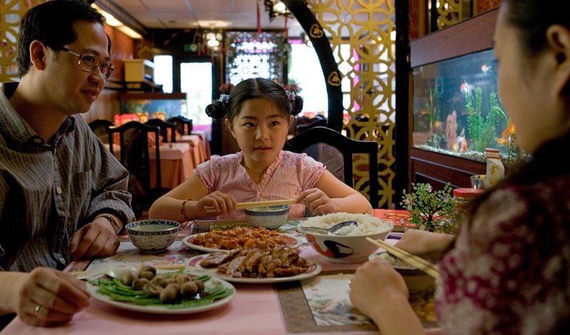 Die Familie Wong in ihrem Restaurant beim Mittagessen. V.li.: Vater (Aaron Wan), Winky (Ebbie Tam) und die Mutter (Hanyi Han). – Bild: BR/​Dinand van der Wal
