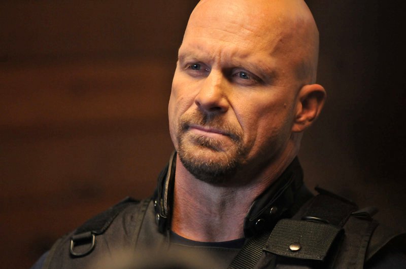 Captain Tate (Steve Austin) führ mit seinem SWAT-Team in einem verlassenen Flugzeughangar eine Übung durch, als plötzlich aus dieser Trainingssituation lebensbedrohlicher Ernst wird. – Bild: Splendid