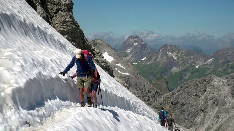 Bergsteiger durchqueren ein Schneefeld auf dem Heilbronner Weg. – Bild: HR/​Boris Wloka