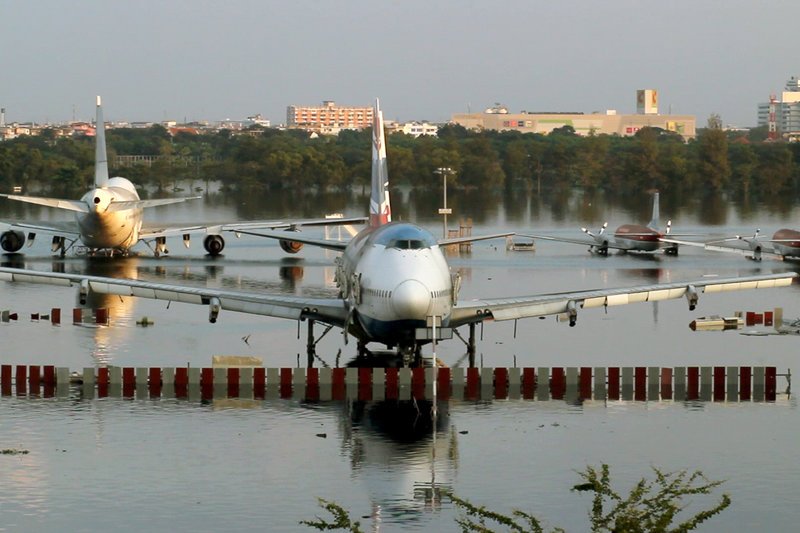 Flugzeuge stehen auf dem Flughafen von Bangkok aufgrund einer Überschwemmung im Wasser. – Bild: ARTE France /​ © AP