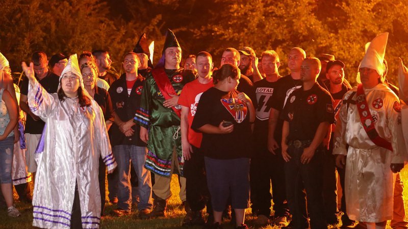 Picture Shows: Group photograph of KKK Loyal White Knight members after their cross burning ceremony in rural Alabama. Woman at front left with arm in the air is Amanda Barker. Man in green robe and red sash is James Moore /​ Ku Klux Klan – Bild: Sarah Foudy /​ Copyright BBC 2015