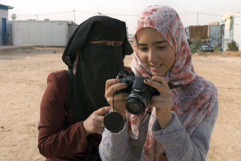 Fatima Ahmad Al-Dabaas (li.) gibt im Flüchtlingslager Zaatari Fotokurse für Kinder und Jugendliche. Sie wird von der Hilfsorganisation IRD unterstützt. – Bild: ZDF 