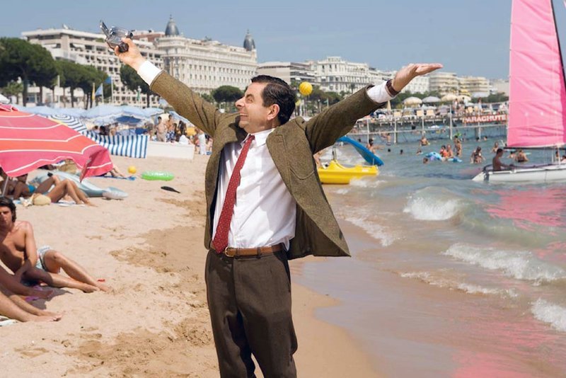 Mr. Bean (Rowan Atkinson) jubelt! Bei einer Lotterie seiner Kirchengemeinde hat er das große Los gezogen: eine Woche Urlaub in Frankreich … – Bild: VOX /​ Universal Studios