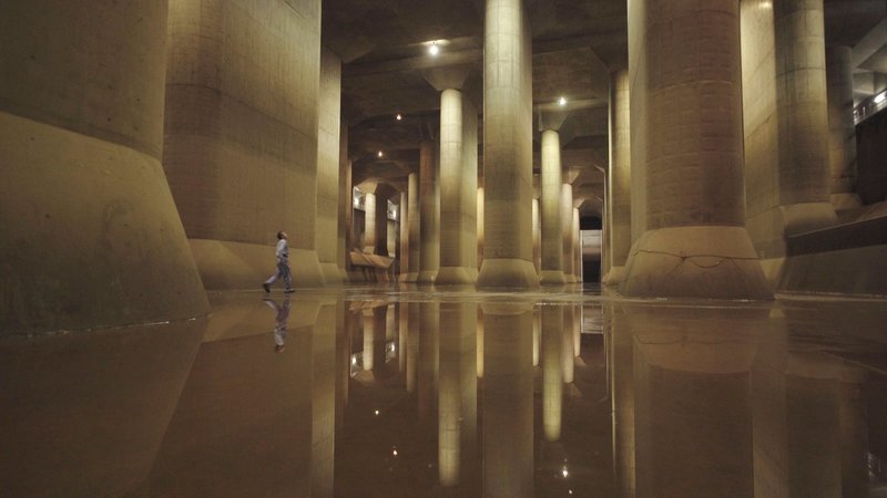 In der Säulenhalle des größten Drainage-Systems der Welt verliert sich Herr Masaki Takahashi. Der Chef des Metropolitan Outer Floodway ist auf Kontrollgang durch die Anlage, die Tokio vor Überflutungen schützen soll. – Bild: ORF