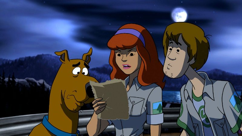 (V.li.) Scooby-Doo, Daphne und Neville lesen in einem Zeitungsausschnitt, dass ein skrupelloser Gefängnisinsasse freigelassen wurde. Ob er etwas mit den Geschehnissen im Feriencamp zu tun hat? – Bild: Super RTL (V.li.) Scooby-Doo, Daphne und Neville lesen in einem Zeitungsausschnitt, dass ein skrupelloser Gefängnisinsasse freigelassen wurde. Ob er etwas mit den Geschehnissen im Feriencamp zu tun hat? – Bild: Super RTL