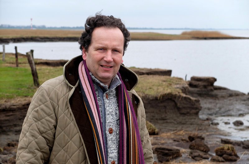 Landwirt Jan-Peter Rüst vor seiner Pachtweide für Mastbullen im Otterndorfer Außendeich. – Bild: NDR/​Ulrich Patzwahl
