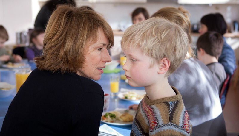 Katharina Bruckner (Corinna Harfouch, l.) und Joe Bremer (Elon Baer, r.) im Kinderheim beim gemeinsamen Essen. – Bild: ZDF und BR/​Conny Klein