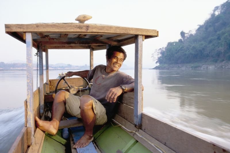 A Laotian man steers his wooden boat along the Mekong River near the Pak Ou Caves in Louangphrabang. – Bild: DCI/​For Show Promotion Only