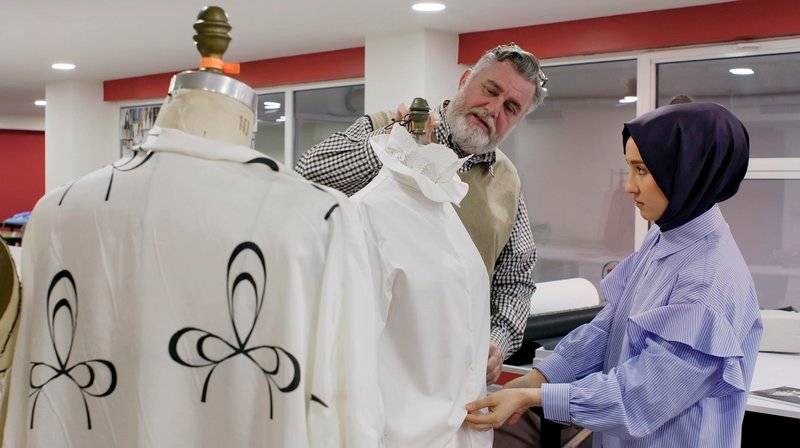 Die junge Designerin Zeynep Serdengeçti (r) begutachtet eine Bluse und lässt sich dabei von ihrem Mentor Guy Lamontagne (l) beraten. Auch bei der sogenannten „modest fashion“ spielen Kreativität, Materialien, Formen, Farben und Design eine große Rolle. – Bild: WDR/​Little Dream Entertainment