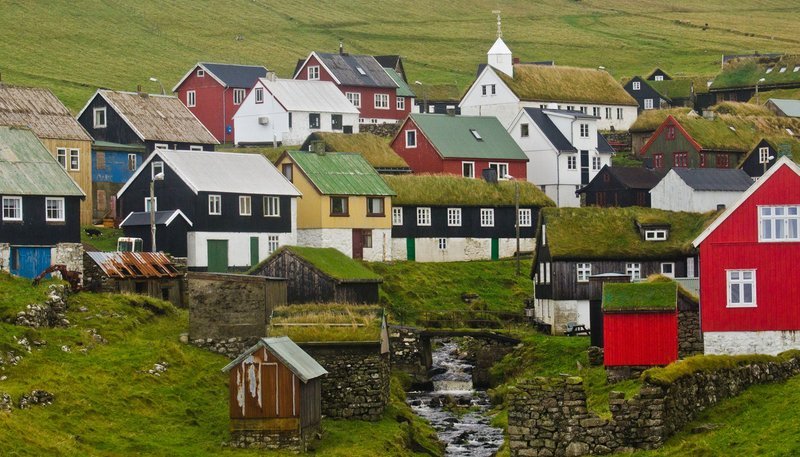 Sattgrün und farbenfroh – Dörfchen auf der Vogelinsel Mykenes. Die Färöer zählen zu den schönsten Inseln der Welt. – Bild: NDR/​Jochen Hauke Wiemer