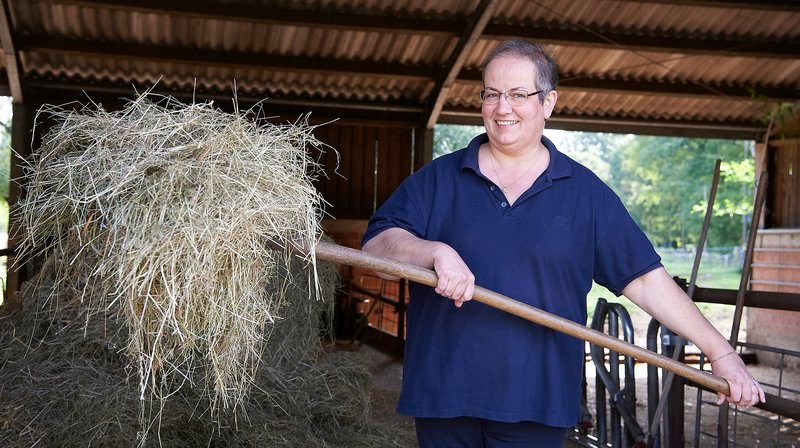 Gastgeberin Astrid Gerdes bei der Stallarbeit auf dem Gamerschlagshof, ein Archehof in Xanten. – Bild: WDR/​Melanie Grande