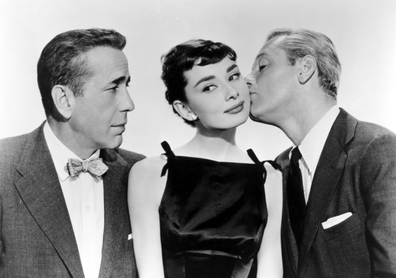 Zwischen zwei Männern: Sabrina (Audrey Hepburn) scheint es zu gefallen, dass Junggeselle Linus (Humphrey Bogart) skeptisch ihre Beziehung zu seinem Bruder und Playboy David (William Holden) betrachtet. – Bild: ORF Zwischen zwei Männern: Sabrina (Audrey Hepburn) scheint es zu gefallen, dass Junggeselle Linus (Humphrey Bogart) skeptisch ihre Beziehung zu seinem Bruder und Playboy David (William Holden) betrachtet. – Bild: ORF