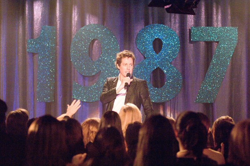 Seit der Trennung von "Pop!", Anfang der Neunziger, schlägt Alex Fletcher (Hugh Grant) sich mit 80er-Retroshows in Vergnügungsparks und auf Jahrmärkten durch, wo er die verstaubten Hits der Band in Karaoke-Qualität vor einer hysterischen Menge von Mittvierzigerinnen zum Besten gibt. Eines Tages erhält er die Chance auf ein Comeback ... – Bild: Puls 4 Seit der Trennung von "Pop!", Anfang der Neunziger, schlägt Alex Fletcher (Hugh Grant) sich mit 80er-Retroshows in Vergnügungsparks und auf Jahrmärkten durch, wo er die verstaubten Hits der Band in Karaoke-Qualität vor einer hysterischen Menge von Mittvierzigerinnen zum Besten gibt. Eines Tages erhält er die Chance auf ein Comeback ... – Bild: Puls 4