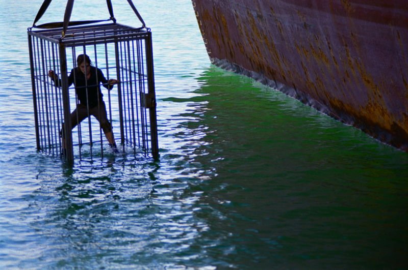 Der Kapitän sperrt Sara (Silke) in einen Käfig in dem er sie ertränken will. – Bild: Squareone