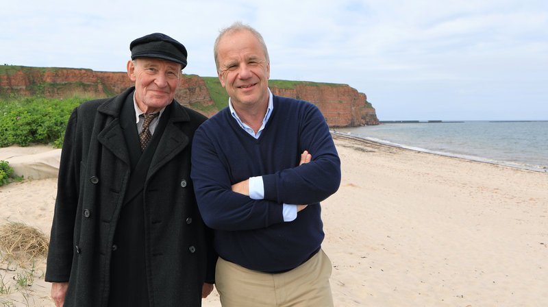 Nach Abschluss der dokumentarischen Dreharbeiten auf Helgoland trifft Presenter Hubertus Meyer-Burckhardt (rechts) am Nordoststrand auf Hauptdarsteller Michael Mendl (links), der am gleichen Tag zum ersten Mal als Helgoländer Fotograf Franz Schensky vor der Kamera steht. – Bild: HR/NDR/DOKfilm/Carsten Schick Nach Abschluss der dokumentarischen Dreharbeiten auf Helgoland trifft Presenter Hubertus Meyer-Burckhardt (rechts) am Nordoststrand auf Hauptdarsteller Michael Mendl (links), der am gleichen Tag zum ersten Mal als Helgoländer Fotograf Franz Schensky vor der Kamera steht. – Bild: HR/NDR/DOKfilm/Carsten Schick
