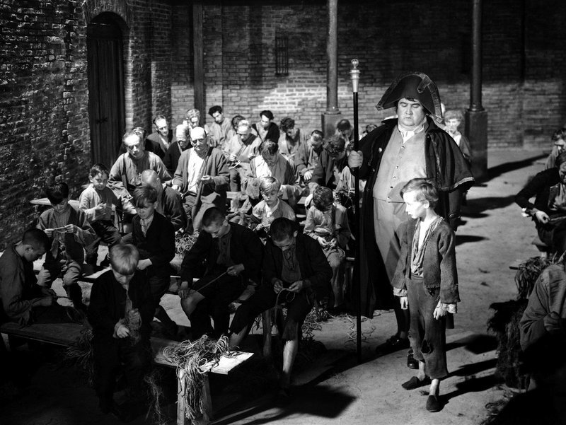 Der Gemeindebüttel Mr. Bumble (Francis L. Sullivan) holt Oliver (John Howard Davies) ab, um ihn für fünf Pfund zu verkaufen. – Bild: MvH – ArtDesign /​ Barum ; fuer ARTE G.E.I.E.