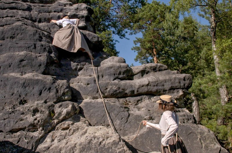 Franka Peemüller (unten) und Kira Mörseburg (klettert) testen das Gefühl, wie man im Rock klettert. – Bild: MDR/​Bettina Wobst