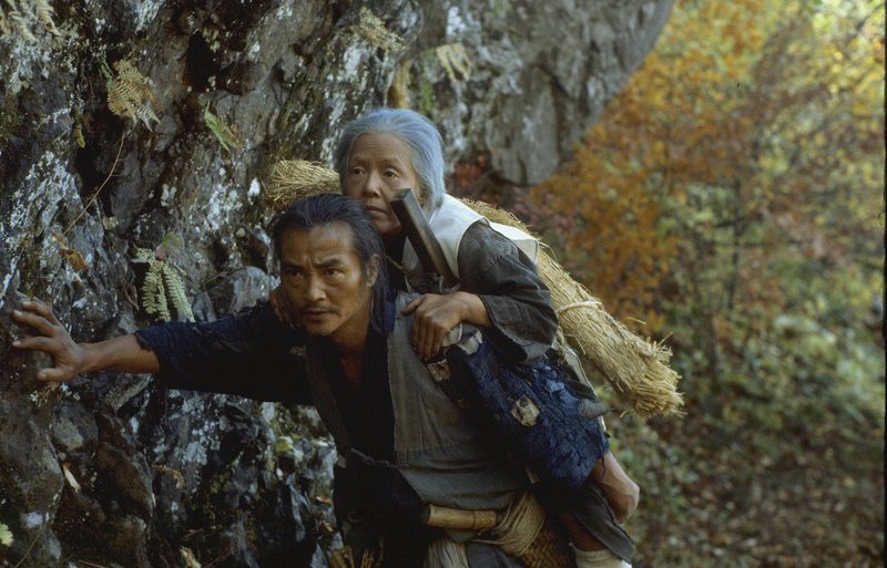 Tatsuhei (Ken Ogata) porte sur dos sa mère Orin (Sumiko Sakamoto) dans le film de Shohei Imamura „La ballade de Narayama“ – Bild: La Rabbia /​ © La Rabbia