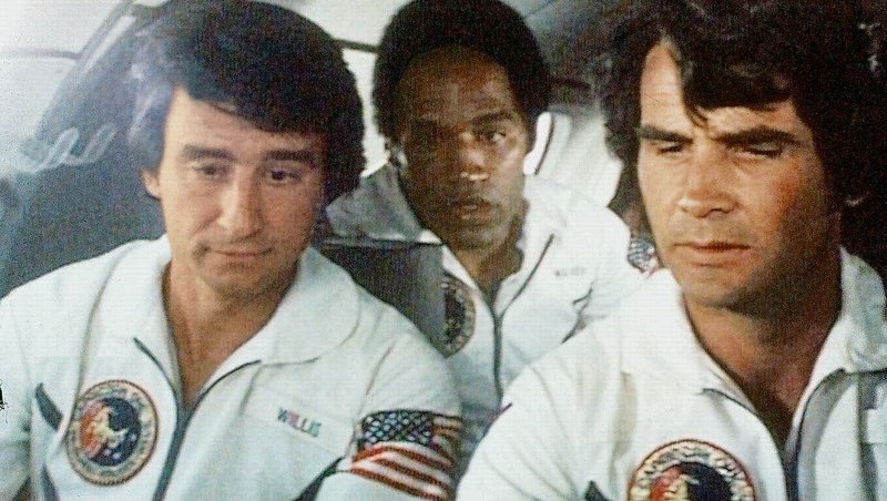 Die drei Astronauten Willis (Sam Waterston, l.), Walker (O.J. Simpson, M.) und Brubaker (James Brolin, r.) stehen kurz vor dem Start zum Mars. Ploetzlich werden sie aus der Raumkapsel geholt und an einen geheimen Ort in der Wueste gebracht. Was fuehrt die NASA im Schilde ? – Bild: ServusTV