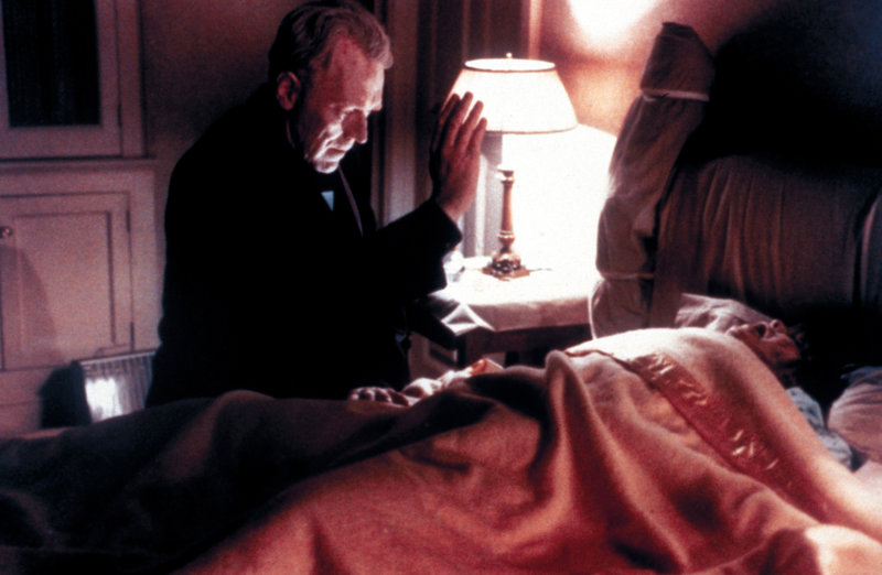 Pater Merrin (Max von Sydow) versucht Regan (Linda Blair) den Teufel auszutreiben. – Bild: TMG Pater Merrin (Max von Sydow) versucht Regan (Linda Blair) den Teufel auszutreiben. – Bild: TMG