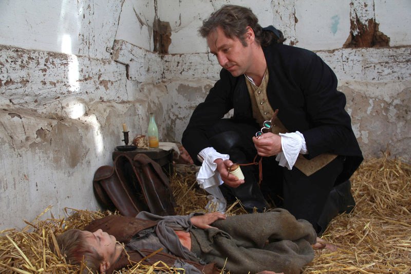 Johann Friedrich Struensee (Nicki von Tempelhoff) untersucht ein Bauernkind. – Bild: ZDF /​ © dmfilm/​Samuel Nerl