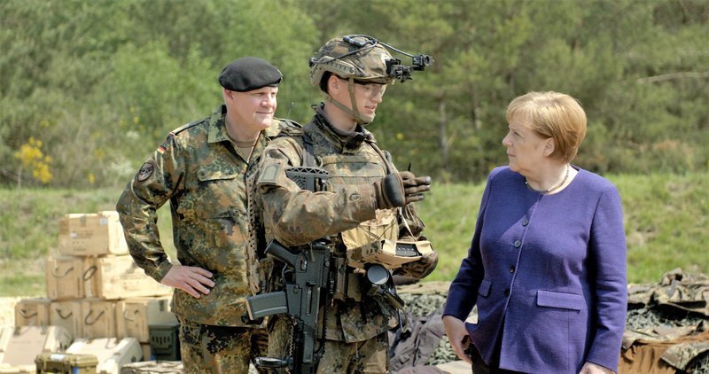Bundeskanzlerin Angela Merkel mit einem Infanteristen der Zukunft auf einem Truppenübungsplatz in Munster im Sommer 2018. – Bild: ZDF und Andreas Orth./​Andreas Orth