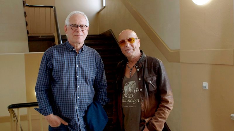 Nur Auserwählte durften aus der DDR in exotische Länder reisen – die AUSLANDSKADER. Hand in Hand mit den vom „kolonialen Joch befreiten“ Brüdern und Schwestern sollten sie die Welt besser und menschlicher – und natürlich ein bisschen sozialistischer – machen. – Peter Kahane und Toni Krahl (re.) – Bild: rbb/​Wolfgang Gaube/​solo:film