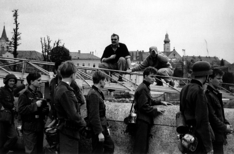 Bernhard Wicki mit seinen Darstellern bei den Dreharbeiten zu „Die Brücke“. – Bild: BR/​Kinowelt