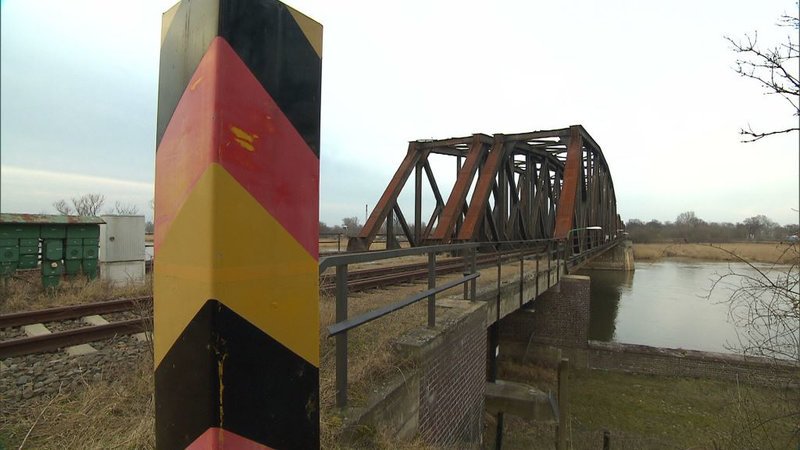 Eine unauffällige Eisenbahnbrücke in der Nähe von Frankfurt/​Oder. In der Mitte des Flusses verläuft die Grenze zu Polen. Deshalb ist die Brücke zu einem beliebten Hehler- und Schmugglerweg geworden. – Bild: ZDF und Jochen Schulze