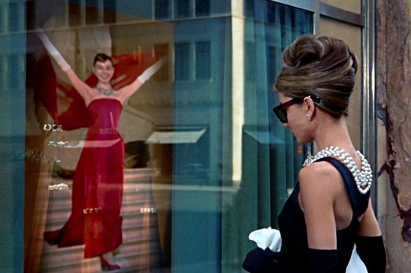 Audrey Hepburn vor dem Schaufenster des Juweliers Tiffany in dem Film „Frühstück bei Tiffany“ (1961): Die Filmfigur Holly träumt von Diamanten, Audrey Hepburn von einem Musical. Sie möchte ihrem Schauspiel einen weiteren Aspekt hinzufügen: den Tanz. – Bild: Zadig Productions Audrey Hepburn vor dem Schaufenster des Juweliers Tiffany in dem Film „Frühstück bei Tiffany“ (1961): Die Filmfigur Holly träumt von Diamanten, Audrey Hepburn von einem Musical. Sie möchte ihrem Schauspiel einen weiteren Aspekt hinzufügen: den Tanz. – Bild: Zadig Productions