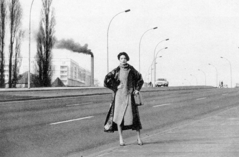 DDR-Model mit grauem Strickkleid und Strickmantel vor einer Straße. – Bild: phoenix/ZDF/Sibylle Bergemann DDR-Model mit grauem Strickkleid und Strickmantel vor einer Straße. – Bild: phoenix/ZDF/Sibylle Bergemann