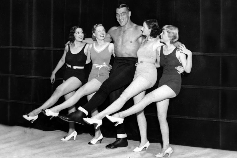 Der Boxer Primo Carnera faszinierte durch seine enorme Größe und Kraft das Publikum. 1933 gewann er die Weltmeisterschaft im Schwergewicht. – Bild: Kuiv Productions /​ Der Boxer Primo Carnera in den 30er Jahren: – stets in guter Gesellschaft