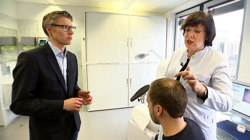Kann man den Kampf um den Haarverlust auf dem Kopf gewinnen? Das sind Fragen, die Mediziner dem rbb Praxis Moderatorenteam Britta Elm und Justus Kliss beantworten. Was geschieht eigentlich bei einer Eigenhaartransplantation, was kann man gegen Alopecia Areata, dem kreisrunden Haarausfall, wirklich tun und was bewirken Haarwuchsmittel gesundheitlich? – rbb-Reporter Justus Kliss (li.) und Prof. Blume-Peytaví vom Kompetenzzentrum für Haare und Haarerkrankungen, Charité Berlin – Bild: rbb/​Erika Brettschneider
