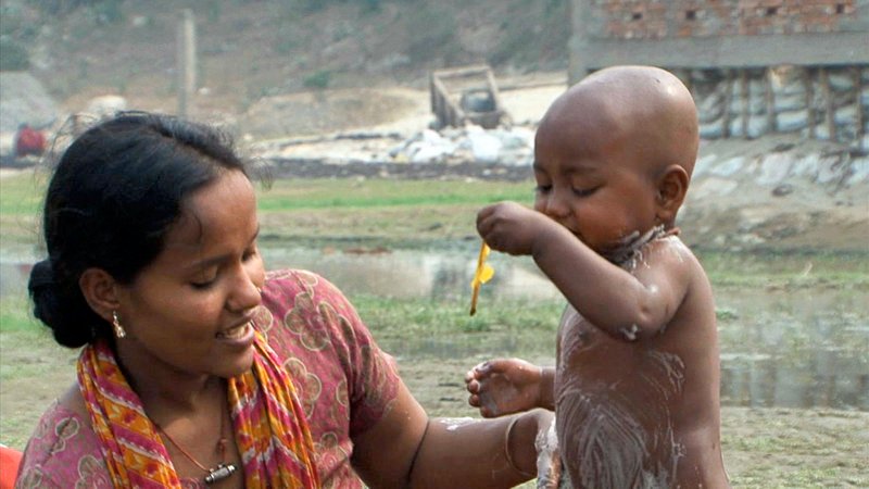 Sharmin mit ihrer dreijährigen Tochter: Wie viele andere der Hunderttausend Einwohner ihres Slums ist auch sie von der Lederindustrie abhängig. – Bild: NDR /​ © Soumen Guha Sontu & Dipak Chandra Sutradhar/​WA Productions