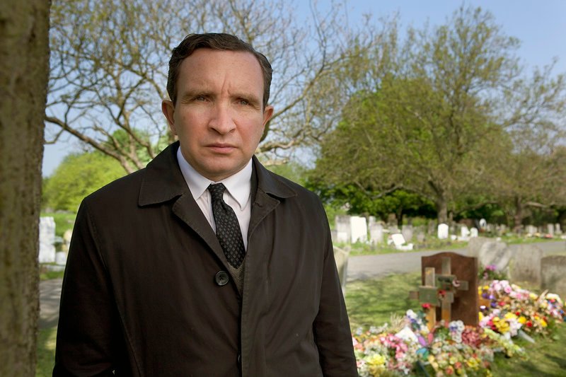 Mr. May (Eddie Marsan) geht seinem Beruf mit Hingabe nach. Er ermöglicht einsam Verstorbenen eine würdevolle Beerdigung. – Bild: ARTE France /​ © Condor Distribution