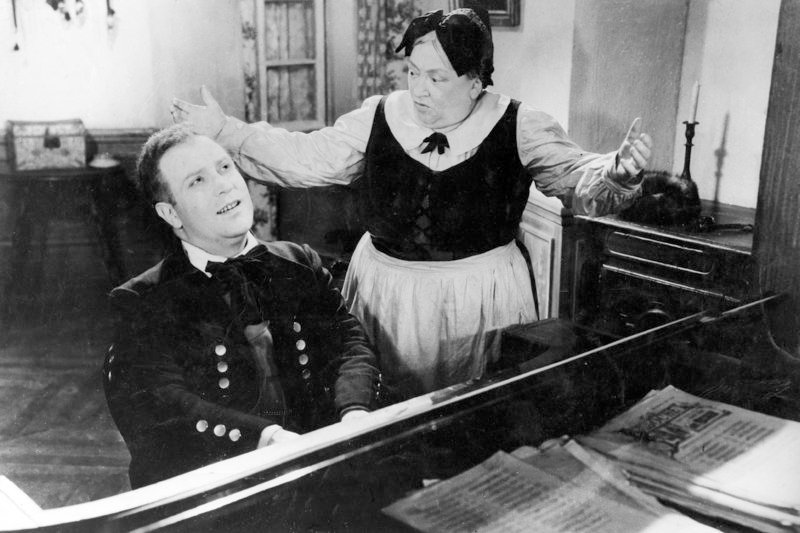 Fritz Kobus (Lucien Duboscq) am Klavier, neben ihm die Bedienstete Catherine (Madeleine Guitty) – Bild: ARTE 