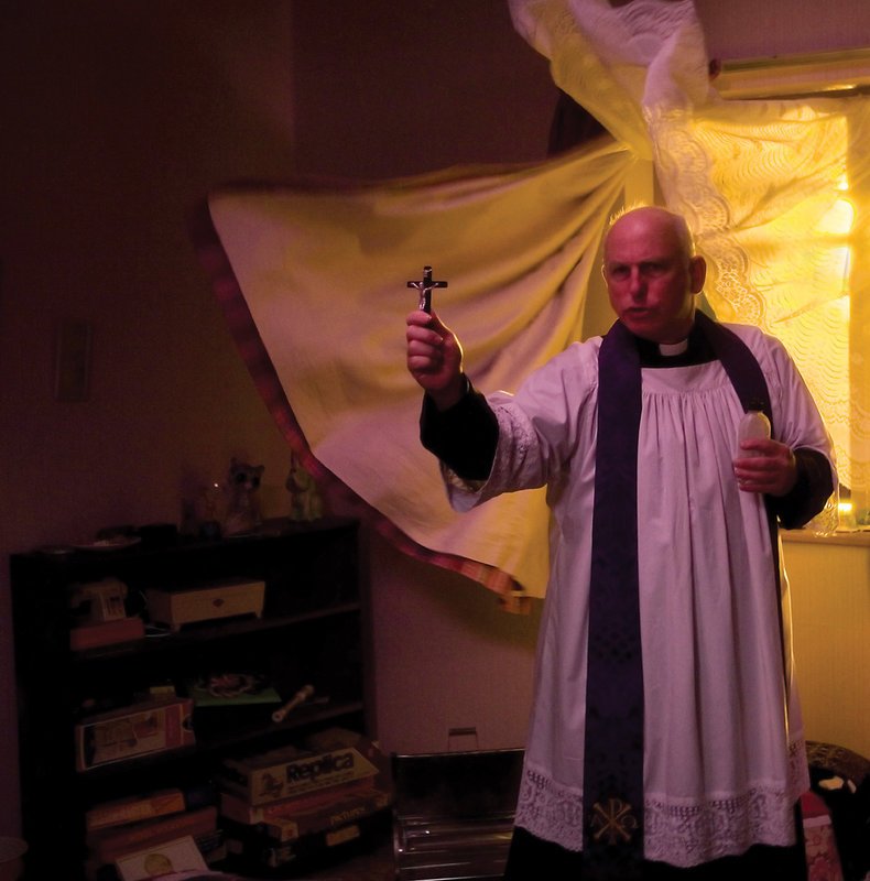 Mutter Jenny will sich keinesfalls geschlagen geben und versucht den Störenfried mit Pater Clifton (Gary Lewis) und einem Exorzismus aus dem Haus zu jagen. – Bild: Ascot Elite