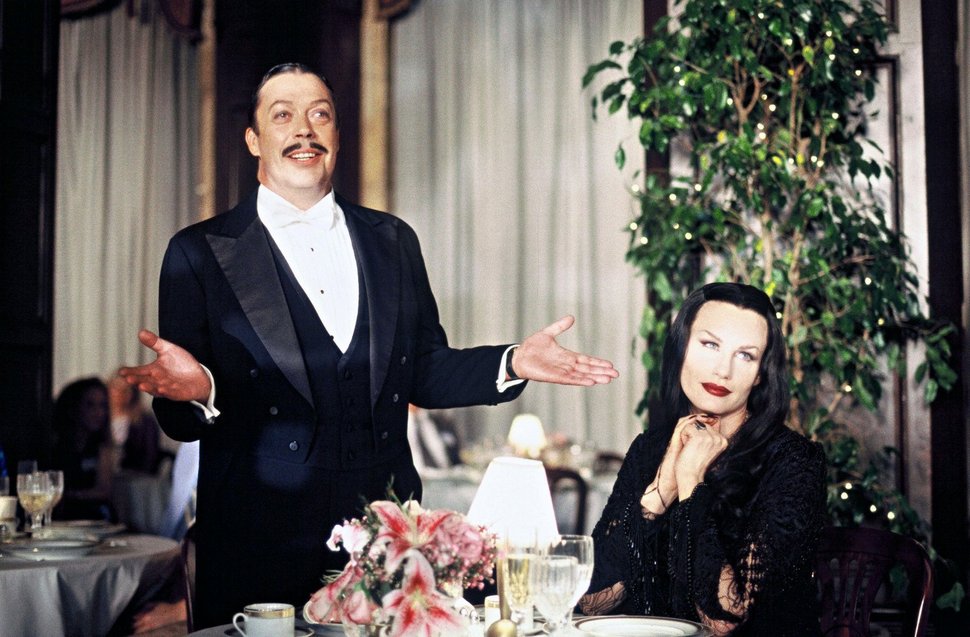 Gomez (Tim Curry) und seine Gattin Morticia (Daryl Hannah) planen einen Treff in einem Urlaubshotel. Man ahnt es schon: das Chaos ist vorprogrammiert. – Bild: Disney Channel