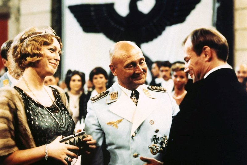 Der Schauspieler Hendrik Höfgen (Klaus Maria Brandauer, r.) fühlt sich durch die Aufmerksamkeit des Generals (Rolf Hoppe) und dessen Freundin Lotte Lindenthal (Christine Harbort) geschmeichelt. – Bild: MDR/Cine aktuell Der Schauspieler Hendrik Höfgen (Klaus Maria Brandauer, r.) fühlt sich durch die Aufmerksamkeit des Generals (Rolf Hoppe) und dessen Freundin Lotte Lindenthal (Christine Harbort) geschmeichelt. – Bild: MDR/Cine aktuell