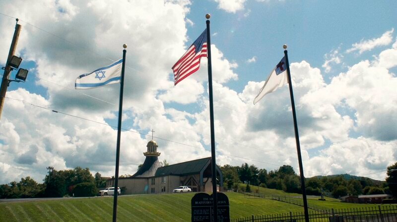 Isralische und amerikanische Flaggen vor einer Kirche in Middlesboro, Kentucky. – Bild: NDR/​Met Film Sales/​Abraham (Abie) Troen