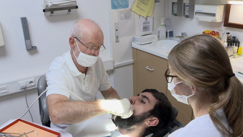 Zahnbehandlungen sind in der Münchner „Praxis für Nichtversicherte“ der Malteser an der Tagesordnung. Dr. Tillmann Haas arbeitet hier ehrenamtlich. – Bild: ZDF und BSP/​Sandra Loeper.